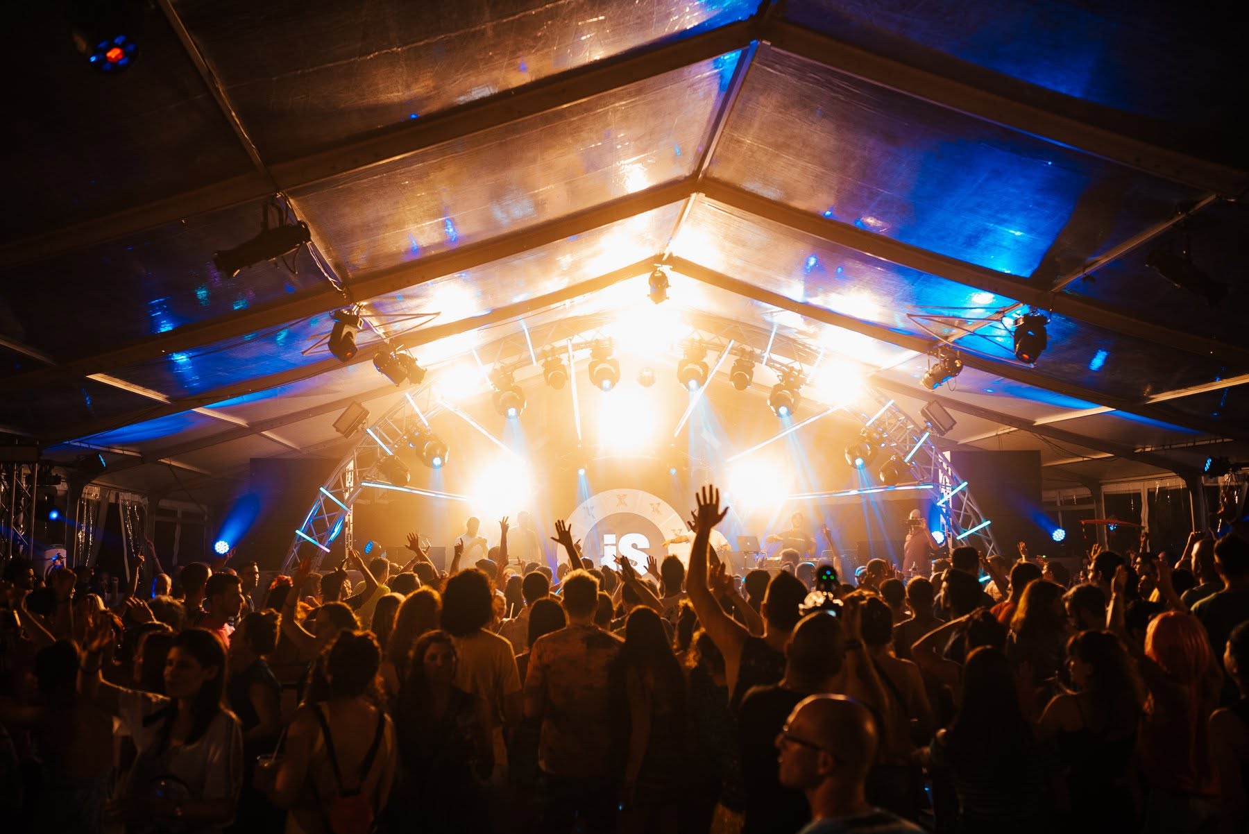 The iS stage logo glowing over the crowd